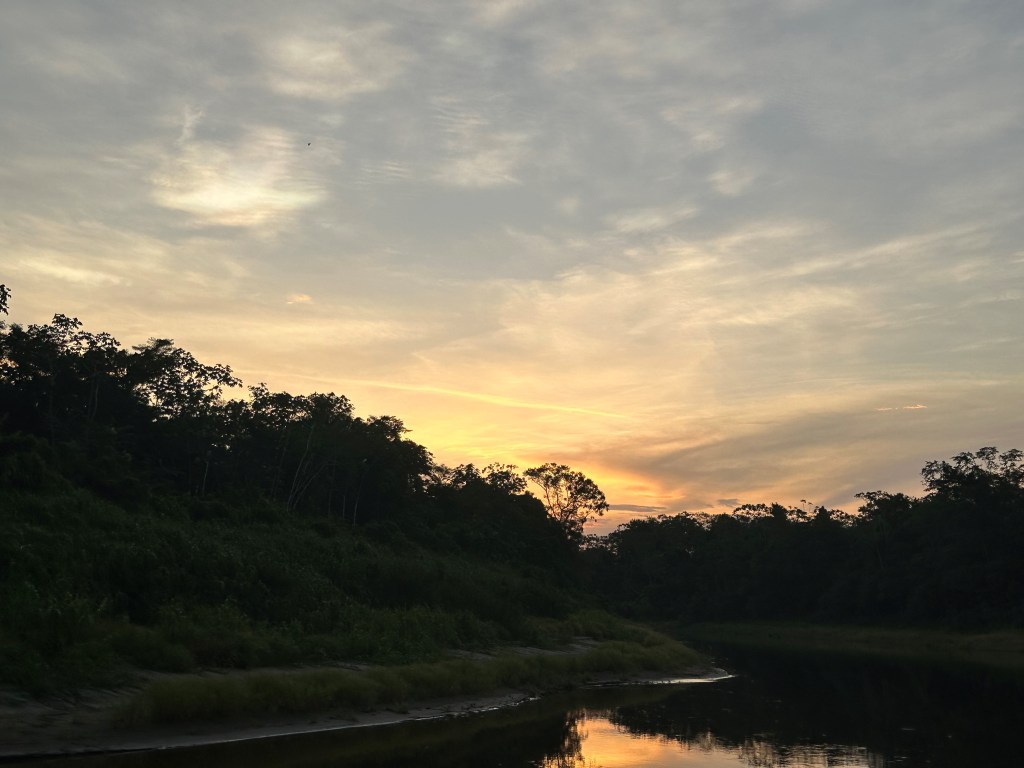 Image shows a beautiful river under a yellow and orange twilight sky.