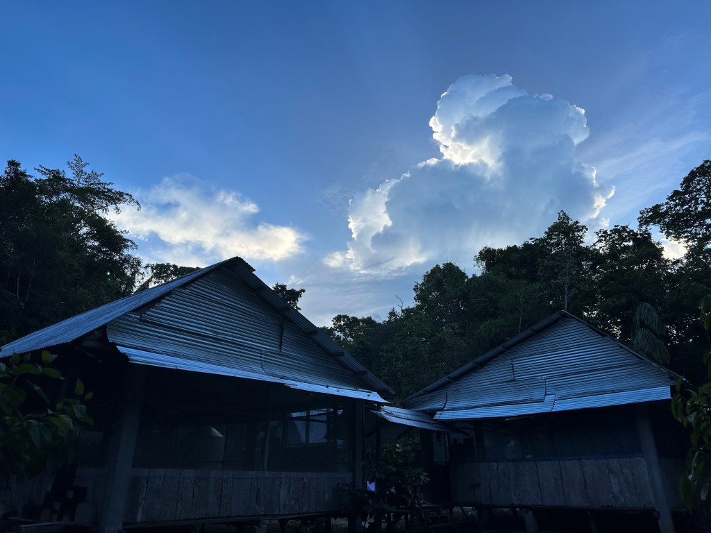 Image depicts two buildings at the field station at Estación Biológica Quebrada Blanco, under a cloudy sky. 